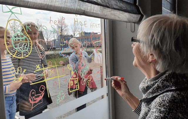 Kinderen de Linderte tekenen samen met oma op het raam